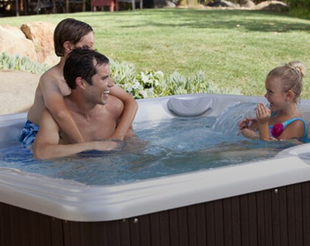 Father playing with kids in Pre-Owned Hot Tub