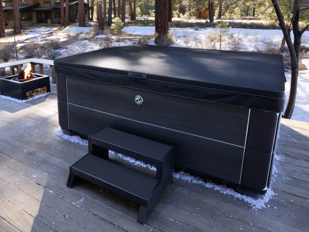 Covered hot tub on a snowy deck with the cover closed to hold heat in during winter